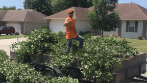 employee loading debris into trailer