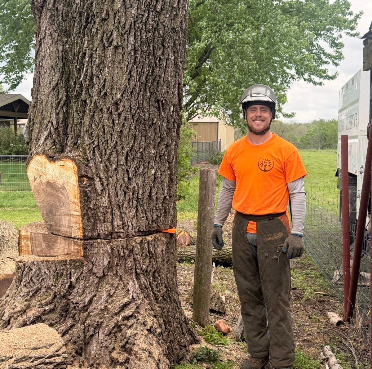 Scott Murphy, Trufast crew lead, smiling beside a big notched trunk on a removal job