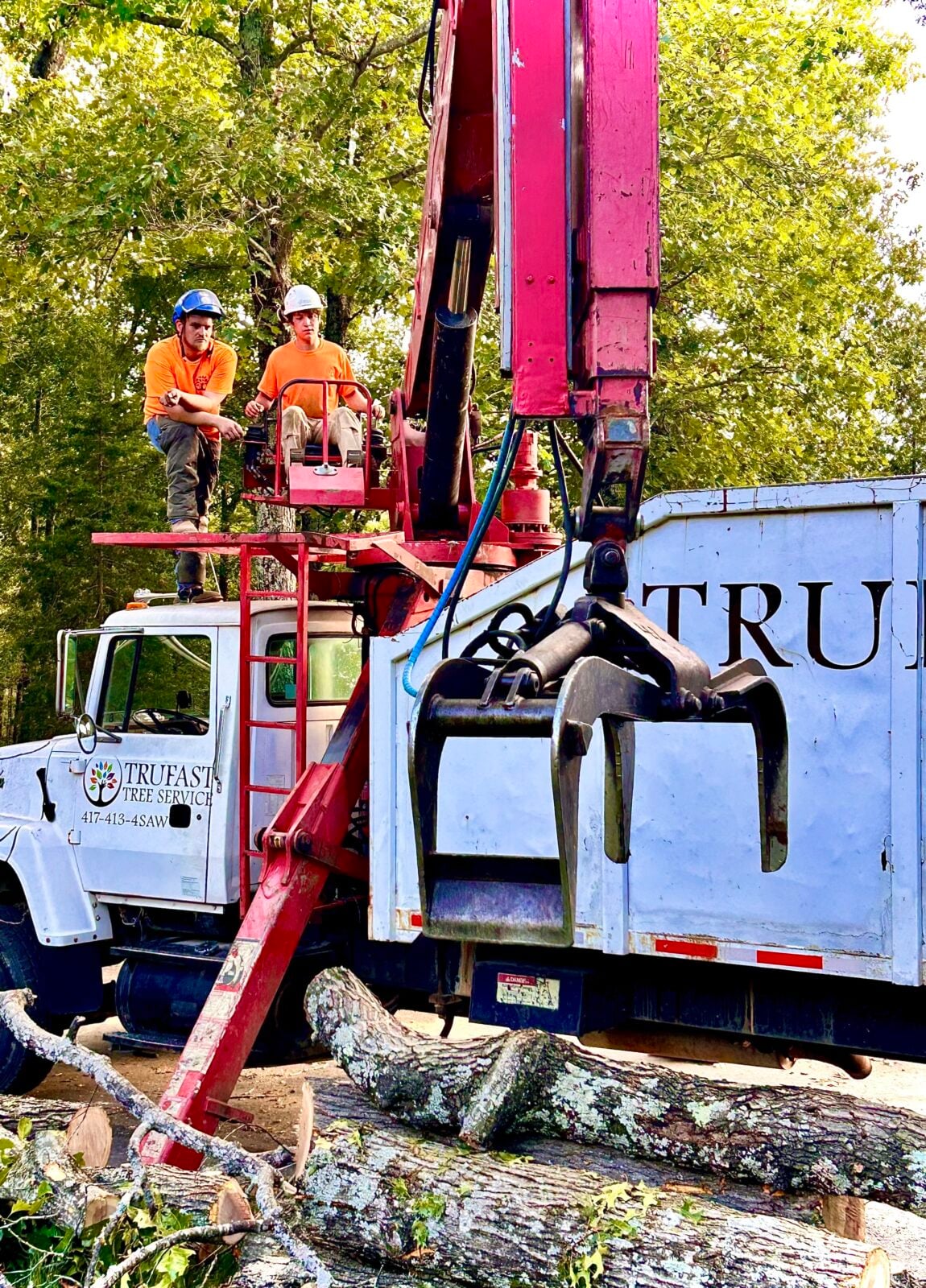 Two crew on Trufast grapple truck with log grapple arm