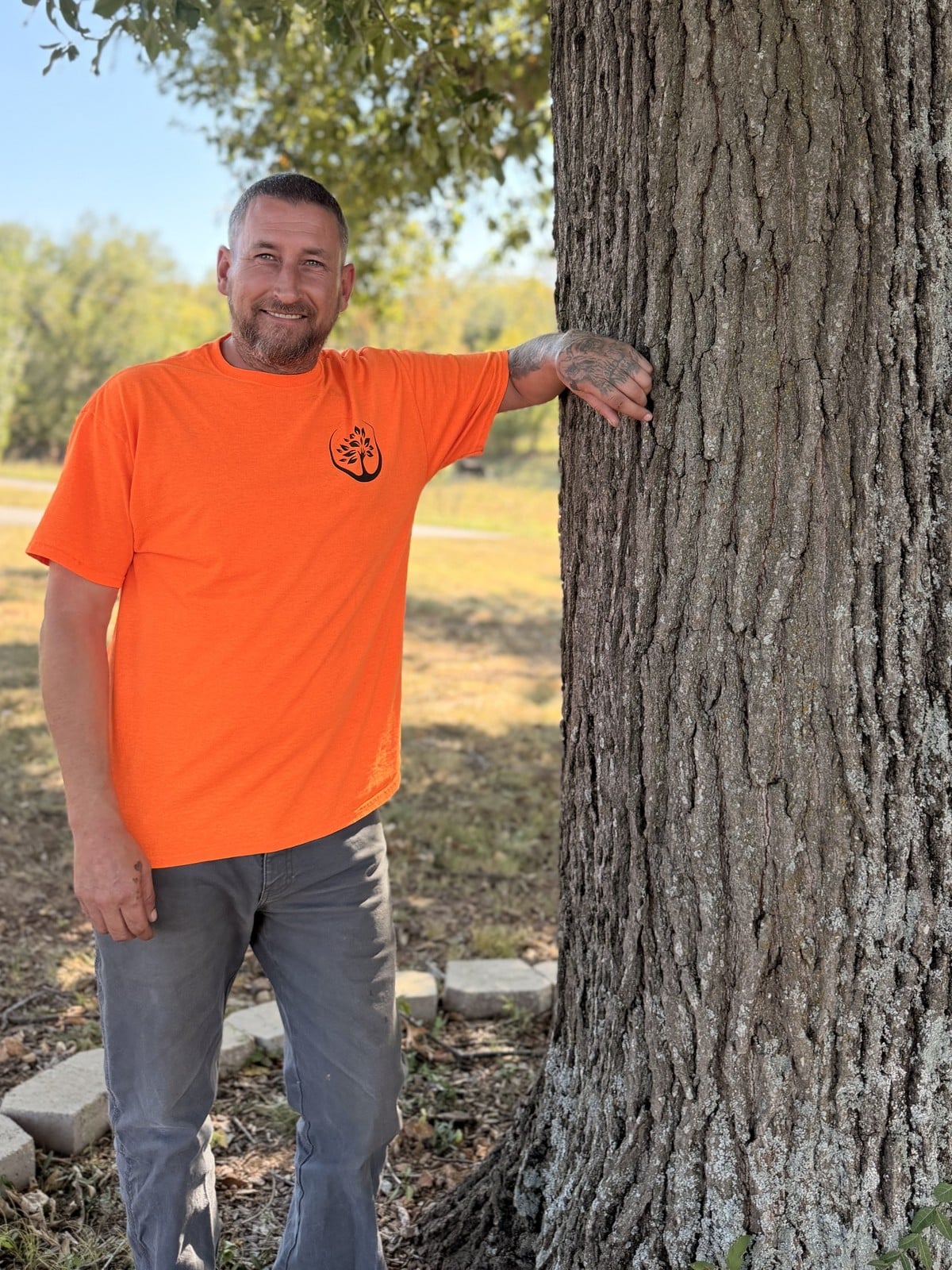 Luke Smith, ISA Certified Arborist and co-founder of Trufast Tree Service, beside a large tree.