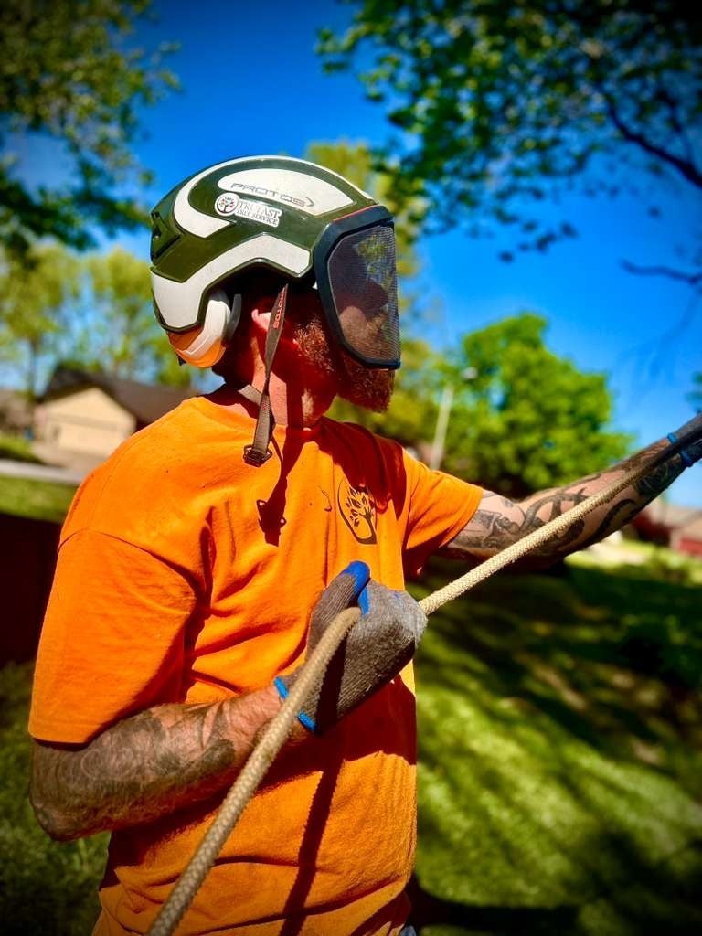 Trufast crew member in a Protos helmet with face screen, ear protection and gloves, working a rigging rope